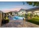 A beautiful backyard features a pool, lounge chairs, a grill, lush landscaping, and outdoor lights at 13750 E Yucca St, Scottsdale, AZ 85259