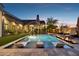 Backyard pool area with built-in lounge chairs, water features, a fireplace, and lush landscaping at 13750 E Yucca St, Scottsdale, AZ 85259