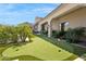 A pristine putting green is surrounded by lush landscaping and an idyllic desert setting at 13750 E Yucca St, Scottsdale, AZ 85259