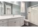 A bathroom features a single sink vanity with a quartz countertop and a clear glass shower at 13850 W Weaver Ct, Litchfield Park, AZ 85340