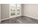 Neutral bedroom features gray walls, wood-look tile flooring, and window with white shutters at 13850 W Weaver Ct, Litchfield Park, AZ 85340
