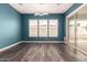 Dining room featuring blue walls, tile flooring, three windows and a glass sliding door at 13850 W Weaver Ct, Litchfield Park, AZ 85340