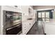 A modern kitchen with stainless steel oven, white countertops, tile backsplash, and ample cabinet space at 13850 W Weaver Ct, Litchfield Park, AZ 85340