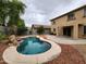 Backyard oasis featuring a freeform pool with rock feature and patio area at 13921 W Port Royale Ln, Surprise, AZ 85379