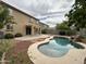 Lush backyard featuring a freeform pool with a mature, landscaped perimeter and patio at 13921 W Port Royale Ln, Surprise, AZ 85379
