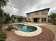 Backyard oasis featuring a freeform pool, rock feature, and low-maintenance landscaping at 13921 W Port Royale Ln, Surprise, AZ 85379