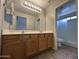 Bathroom with double sink vanity and shower with glass door at 13921 W Port Royale Ln, Surprise, AZ 85379