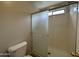 Bathroom showcasing a glass shower door, toilet and window at 13921 W Port Royale Ln, Surprise, AZ 85379
