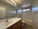 Well-lit bathroom featuring a large mirror, a vanity with storage, and a shower-tub combo at 13921 W Port Royale Ln, Surprise, AZ 85379