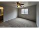 Spacious carpeted bedroom with a ceiling fan and ample natural light at 13921 W Port Royale Ln, Surprise, AZ 85379