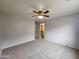 Spacious carpeted bedroom with a ceiling fan, closet, and access to walk-in closet at 13921 W Port Royale Ln, Surprise, AZ 85379