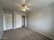 Bedroom with carpet, ceiling fan, closet and entry doors at 13921 W Port Royale Ln, Surprise, AZ 85379
