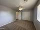 Bedroom features neutral walls, carpet, ceiling fan and a window for natural light at 13921 W Port Royale Ln, Surprise, AZ 85379