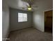 Bedroom with carpet, ceiling fan, and window providing natural light at 13921 W Port Royale Ln, Surprise, AZ 85379