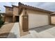 Charming home featuring a two-car garage, desert landscaping, and a welcoming entrance at 13921 W Port Royale Ln, Surprise, AZ 85379