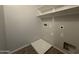 A view of the laundry room area with white utility shelf and tile floor at 13921 W Port Royale Ln, Surprise, AZ 85379