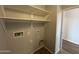 A view of the laundry room area with white utility shelf and tile floor at 13921 W Port Royale Ln, Surprise, AZ 85379
