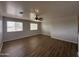 Spacious living room featuring wood floors, a ceiling fan, and large windows at 13921 W Port Royale Ln, Surprise, AZ 85379