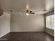 Spacious living room featuring tile flooring, a ceiling fan, and large windows with natural light at 13921 W Port Royale Ln, Surprise, AZ 85379