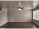 Spacious living room featuring tile flooring, a ceiling fan, and large windows with natural light at 13921 W Port Royale Ln, Surprise, AZ 85379