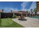Inviting backyard boasts an umbrella dining set, putting green, and a sparkling pool at 1461 W Tara Dr, Gilbert, AZ 85233