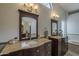 Bathroom features dual sinks with dark wood cabinets, granite countertops, and a large arched window for natural light at 1461 W Tara Dr, Gilbert, AZ 85233