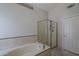 Bright bathroom with soaking tub and glass enclosed shower; features neutral tile, and a linen closet at 1461 W Tara Dr, Gilbert, AZ 85233