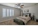 Bedroom with a ceiling fan, plantation shutters, and decor, providing a comfortable living space at 1461 W Tara Dr, Gilbert, AZ 85233