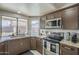 A well-lit kitchen with stainless steel appliances, granite countertops, and views of the backyard at 1461 W Tara Dr, Gilbert, AZ 85233