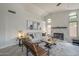 Cozy living room with a fireplace, white walls, and neutral-toned furniture at 1461 W Tara Dr, Gilbert, AZ 85233