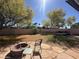 Large backyard with mature trees, a rock firepit and privacy wall at 14617 S 35Th Pl, Phoenix, AZ 85044