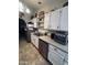 Galley kitchen featuring white cabinets, stainless steel appliances, and tile flooring at 14617 S 35Th Pl, Phoenix, AZ 85044