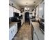 Galley kitchen with appliances, white cabinets, tile flooring, and eat-in breakfast nook at 14617 S 35Th Pl, Phoenix, AZ 85044