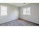 A simple bedroom with neutral walls and carpeting, plus two windows at 14881 W Ashland Ave, Goodyear, AZ 85395