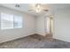 A bedroom with neutral walls and carpeted floor, window and archway to another room at 14881 W Ashland Ave, Goodyear, AZ 85395