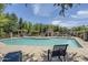 Community pool with lounge chairs, ramada, and lush green trees at 14881 W Ashland Ave, Goodyear, AZ 85395