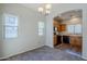 Cozy dining area leading to the kitchen, featuring wood floors and a stylish light fixture at 14881 W Ashland Ave, Goodyear, AZ 85395