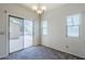 Bright dining room with a sliding glass door, modern lighting, and neutral walls at 14881 W Ashland Ave, Goodyear, AZ 85395