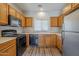 Efficient kitchen with wooden cabinets, black appliances, and a bright window at 14881 W Ashland Ave, Goodyear, AZ 85395