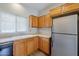 Kitchen with wood cabinets, stainless steel refrigerator, and bright natural light at 14881 W Ashland Ave, Goodyear, AZ 85395