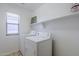 Bright laundry room with machines, shelf storage, and window with blinds at 14881 W Ashland Ave, Goodyear, AZ 85395