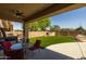 Expansive backyard featuring green artificial turf, covered patio, and a sparkling pool with rock waterfall at 16206 W Cocopah St, Goodyear, AZ 85338