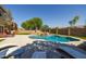Relaxing backyard featuring a pool, spa with rock waterfall, and lounge seating at 16206 W Cocopah St, Goodyear, AZ 85338