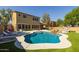 Spacious backyard featuring a pool, spa with rock detail, patio, and lush landscaping at 16206 W Cocopah St, Goodyear, AZ 85338