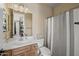 This bathroom features striped wallpaper, a white vanity, and a shower with a striped curtain at 16206 W Cocopah St, Goodyear, AZ 85338