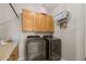 Laundry room featuring updated washer and dryer, overhead storage, and a granite countertop at 16206 W Cocopah St, Goodyear, AZ 85338