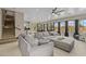Open floorplan in the living room with a large sectional sofa, view of the kitchen, and an outdoor pool area at 16206 W Cocopah St, Goodyear, AZ 85338