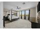 Spacious primary bedroom featuring a four-poster bed, ceiling fan, and lots of natural light at 16206 W Cocopah St, Goodyear, AZ 85338
