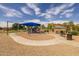 Community playground featuring slides, swings, picnic benches, and a blue shade canopy at 16206 W Cocopah St, Goodyear, AZ 85338