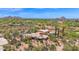 Expansive aerial view of a desert home, showcasing lush landscaping, golf course, and mountain views at 1702 E Staghorn Ln, Carefree, AZ 85377